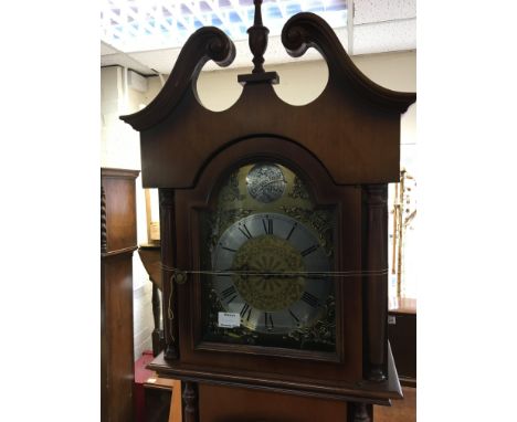 A modern longcase clock with a brass dial silvered chapter ring and visible weights.