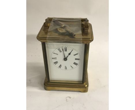 A brass case carriage clock the enamel dial with Roman numerals.