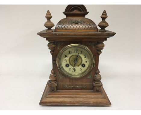 A Continental walnut mantel clock with metal mounts. Hight 36cm