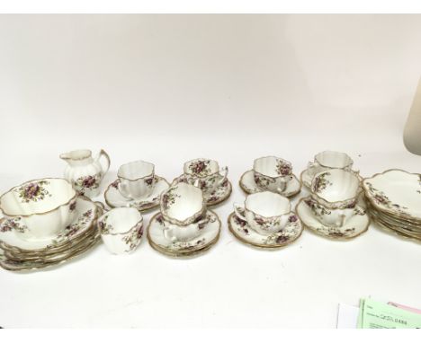 An Edwardian Melba China tea set decorated with flowers and gilt some hairline cracks three cups.