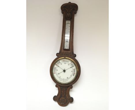 A walnut Aneroid barometer with a white enamel dial.