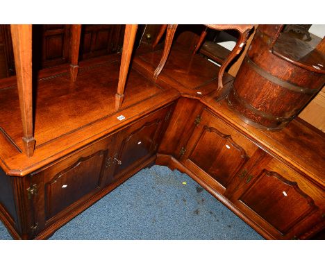 A REPRODUCTION OAK THREE SECTION CORNER UNITS, the corner section with hinged top, two sections with double cupboard doors an