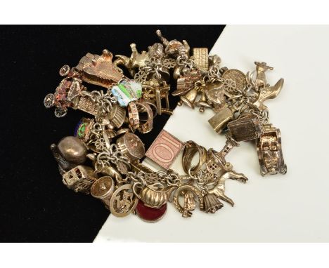 A CHARM BRACELET, the fancy link bracelet with spring ring clasp suspending forty eight charms, to include a hinged tankard, 