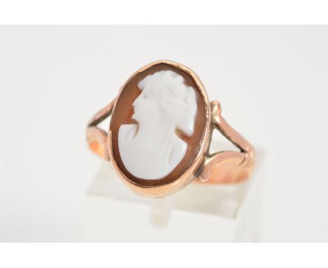 AN EARLY 20TH CENTURY 9CT GOLD CAMEO RING, designed as an oval cameo within a collet setting to the bifurcated shoulders, sta