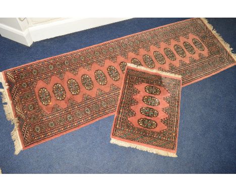 A TEKKE STYLE ORANGE GROUND CARPET RUNNER together with a matching small rug (2)