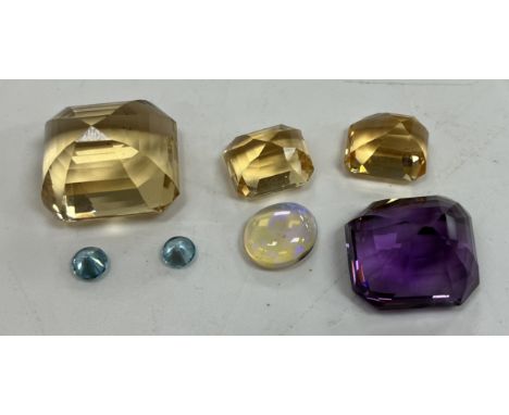 A collection of seven various cut stones including opal, amethyst, topaz, cubic zirconia, aquamarine, etc.