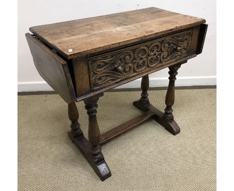 A 20th Century oak side table in the 17th Century style, the plain top with two drop leaves over a carved single drawer on ba