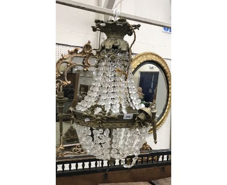 A modern brass mounted cut glass drop bag style ceiling light with three interior lights and three exterior candle type light