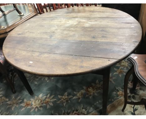 A 19th Century oak dining table, the circular plank top above a plain frieze with single end drawer on square tapered legs, 1