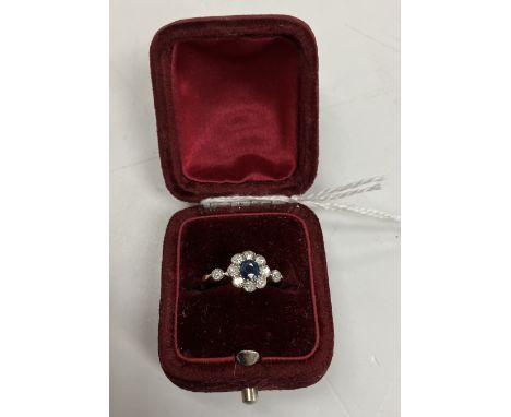 An early to mid 20th Century yellow metal mounted sapphire and diamond flower head dress ring, the central stone approx 0.25 