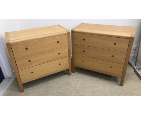 A pair of modern oak three drawer chests, the plain top with plank detail and rounded top corners, the handles as finger hole