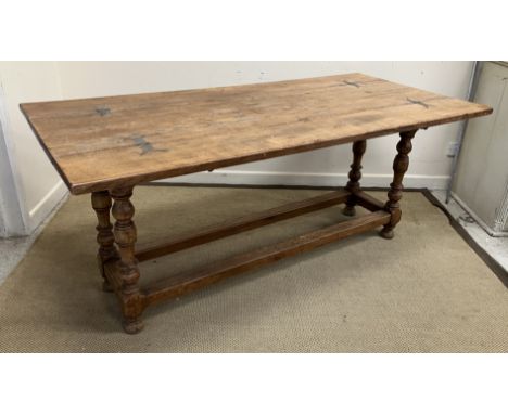 A modern oak dining table in the 17th Century manner, the double fold over plank top on turned and ringed supports to block f
