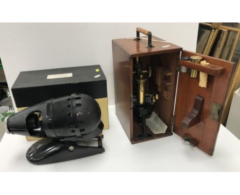 An early 20th Century Swift & Son of London brass and anodised cased monocular microscope and accessories in a mahogany case,
