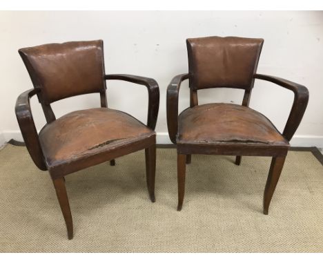A pair of 1930s beech framed brown leather upholstered elbow chairs on square tapered slightly splayed supports together with
