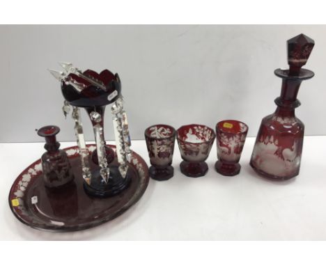 A Bohemian ruby overlaid cut glass decanter and stopper, the mallet shaped faceted main body decorated with stag and doe in a