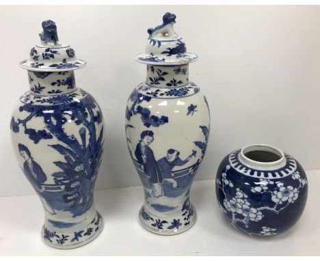 A pair of 19th Century Chinese blue and white baluster shaped vases and covers, the main bodies decorated with figures in a g