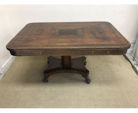 A Regency yew wood rosewood cross banded and brass inlaid breakfast table, the rounded rectangular top on an octagonal pedest