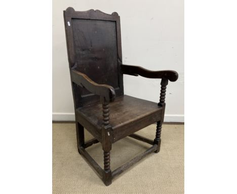 An18th Century and later oak hall chair, the shaped top rail over a plain panel and scroll arms on bobbin turned supports, th