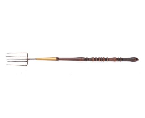 A 19th Century iron, brass and turned wood flesh fork: with five prongs and brass mounted beech turned handle, 75cm long.
