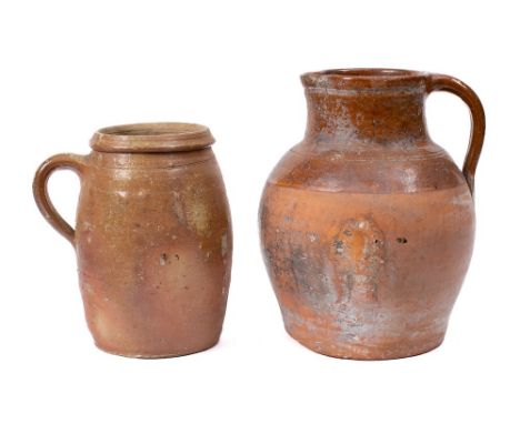 A ribbed terracotta ewer: of oviform shape, 30cm high, a terracotta and slip glazed jar with non-matching cover, 32cm high, a
