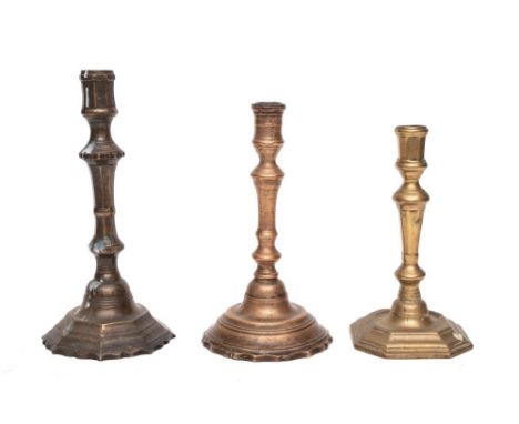 An 18th Century brass candlestick: with turned stem and circular mound base with petal edge, 23.5cm high, another 18th Centur