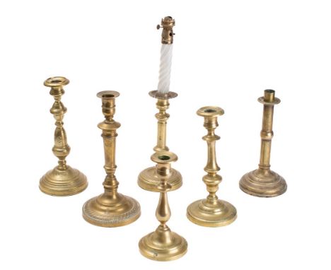 A collection of five various 19th Century brass candlesticks: and a brass candlestick oil lamp. (6)
