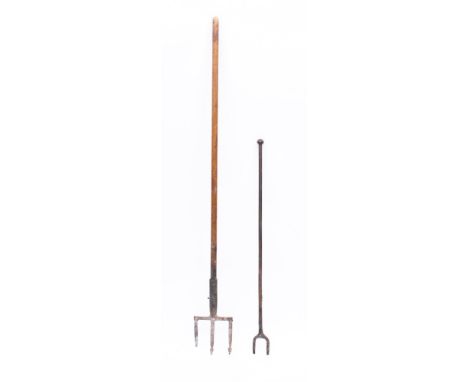 A metal three pronged cooking trident: with long turned wood handle, 156cm long, also an iron two pronged fork. (2)