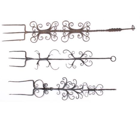 Two decorative three pronged forks: with scroll decorated handles and a similar two pronged fork. (3)