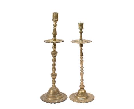 A tall brass candlestick: in the early 18th Century Dutch taste, with turned stem, wide circular drip pan and petal base, 60c