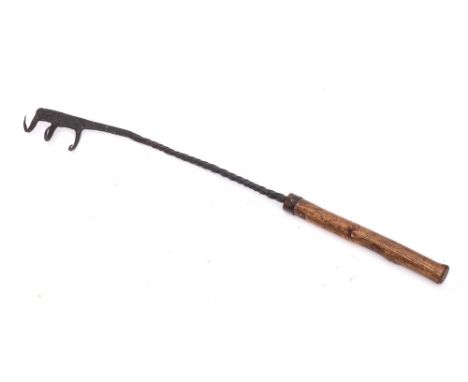 A rare early iron flesh fork: with triple hooks, spiral stem and wood handle, 54.5cm long.* Possibly 14th Century.  A similar