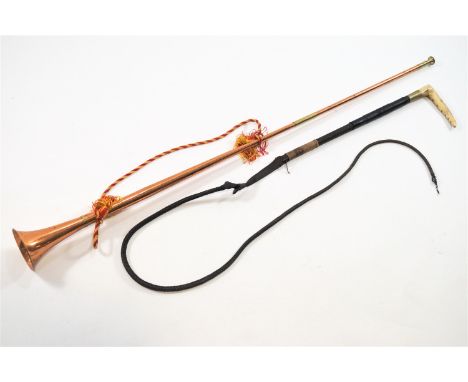 A copper hunting horn and a whip, the horn 125cm long