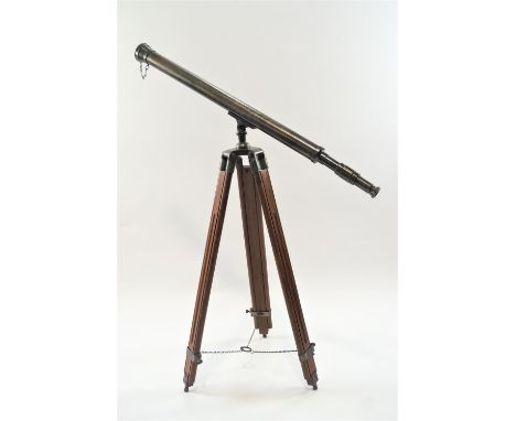 A brass cased field telescope, apparently un-marked, with pull off lens cover, 99cm high, on a metal mounted, hardwood extend