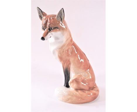 A Royal Worcester fox, seen in the seated position with his brush over his paws, 19cm high