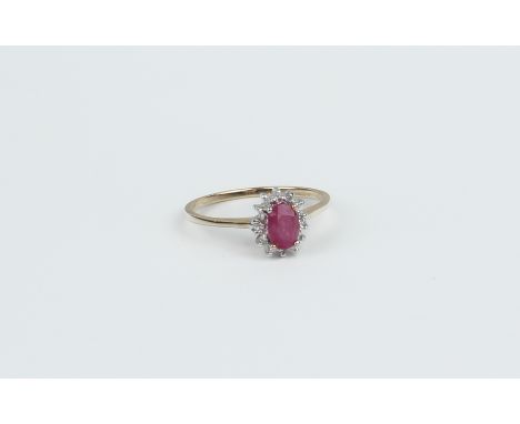 A 9ct gold, ruby and diamond cluster ring - Birmingham hallmarks, the oval cut 6 x 4mm ruby within a border of single cut dia