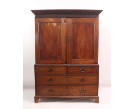 A George III mahogany linen press of compact proportions - the ogee moulded, dentil carved cornice over a blind fret carved f