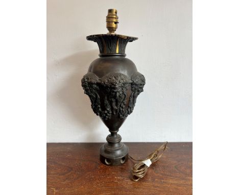 A bronze vase form table lamp - early 20th century, dark brown patination, the parcel gilt flared, foliate neck over an ovoid