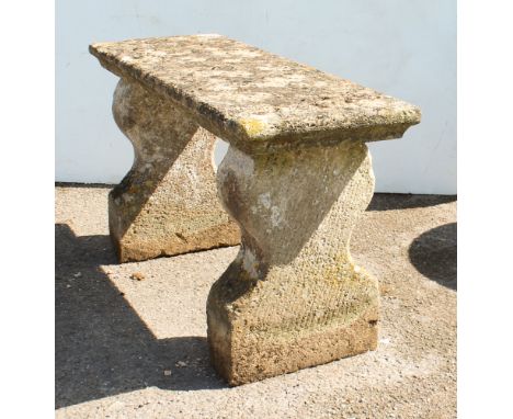 A well weathered composite stone three-part garden bench