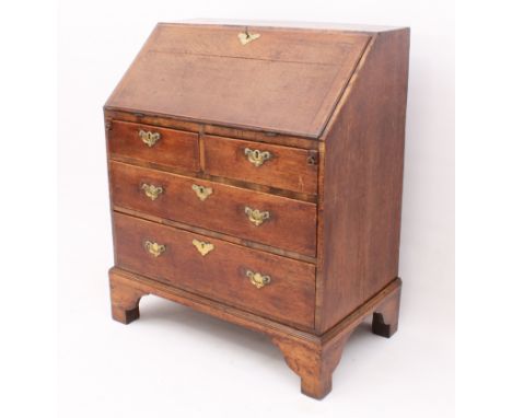 A George III oak and walnut bureau of pleasingly small proportions - the cleated fall front with original iron hinges and bra