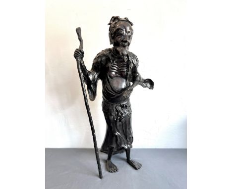 A large Japanese bronze figure of an ascetic immortal - 20th century, the figure with a beard, loose robes with foliage drape