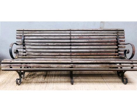 A Victorian style wrought iron park or garden bench - with scroll arms, slatted seat and three scrolled supports, 200cm long,