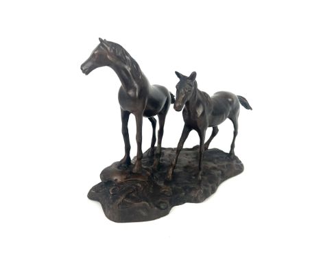 A modern bronze of two horses - unsigned, standing upon a rocky outcrop, mid and dark brown patination, 20.8cm high.