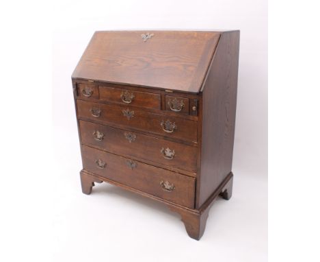 A George III style oak bureau - second half 20th century, the fall front opening to reveal a well fitted interior with a wate