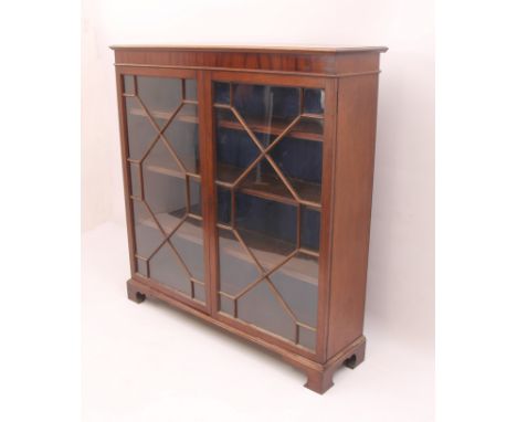 A Georgian-style mahogany glazed bookcase - 1920s, the moulded top over a pair of 13-pane astragal glazed doors, enclosing th