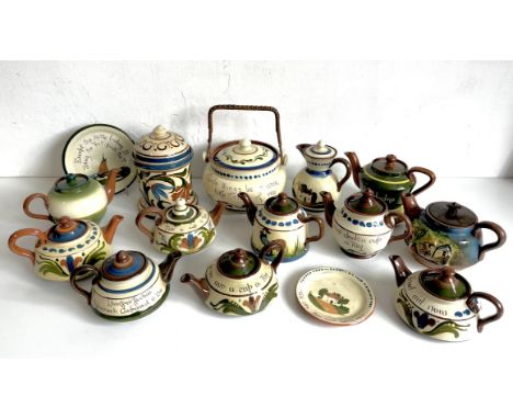 A collection of Torquay pottery teapots, teapots stands, biscuit jars and a lidded jug - including Scandy decorated pieces an