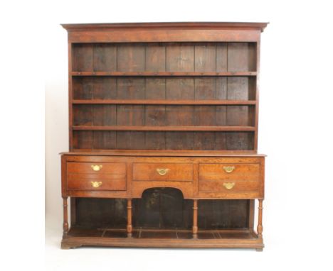 A mid-18th century oak potboard dresser - the ogee cornice over a closed plate-rack with three shelves and gilt-brass hanging