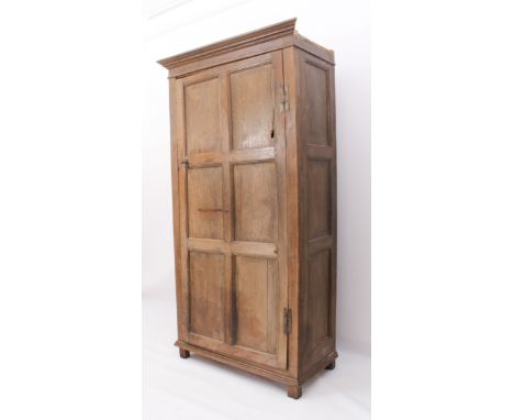 An 18th century panelled oak hanging robe or hall cupboard - the flared, moulded cornice over three-panel sides and a six-pan
