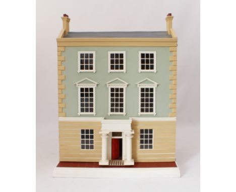A large Georgian-style doll's house - modern, the peaked tiled roof with two chimneys, over a side-hinged front panel with ei