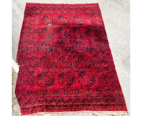 An Afghan Bokhara rug - first half 20th century, with three rows of five octagonal gols on a madder field, within multiple re