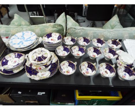 A part tea service with floral gilt decoration on a blue ground to include cups, saucers, plates, cream jug and similar and t