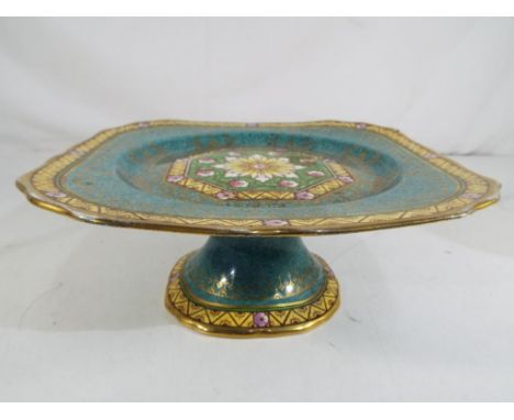 Minton - a Minton ceramic tazza / footed cake plate decorated on a green speckled ground with floral decoration and gilded hi